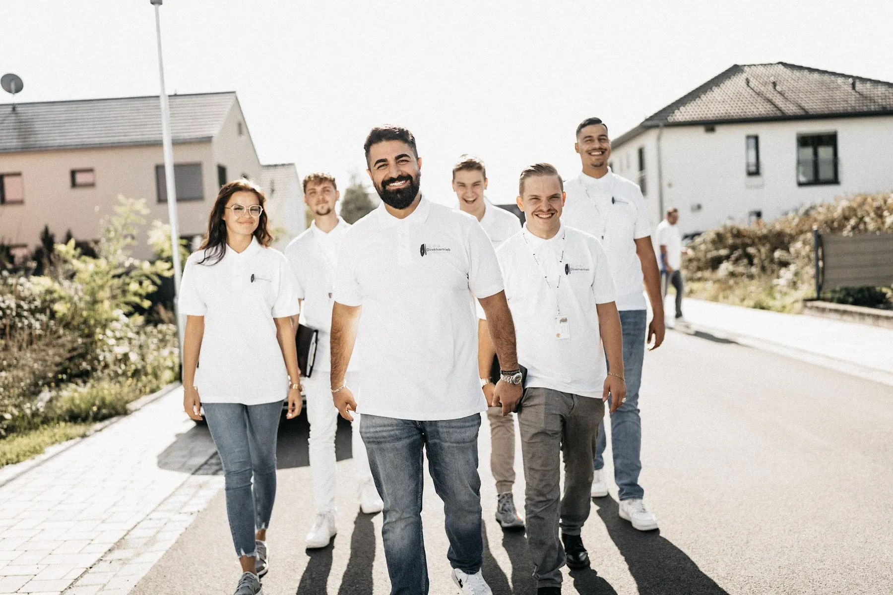 Team von D.A. Direktvertrieb steht gemeinsam in einer Wohnstraße